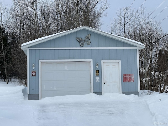 snow covered garage with a garage