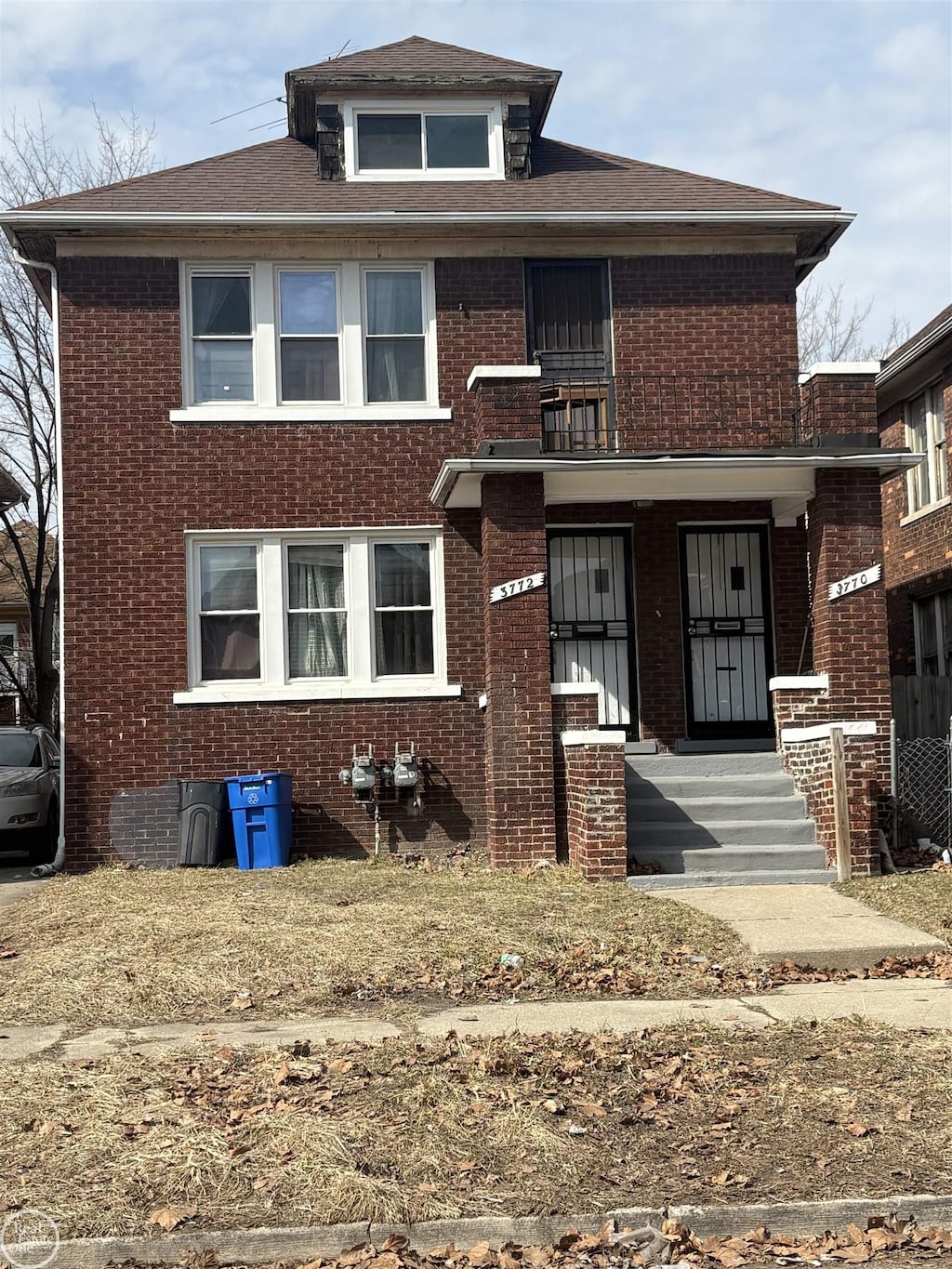 american foursquare style home featuring brick siding