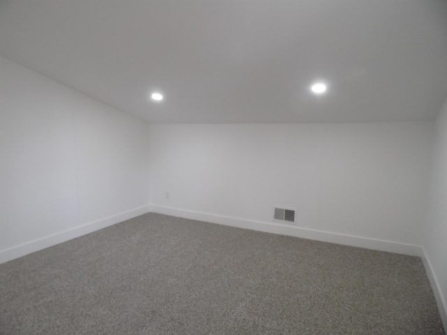 carpeted spare room featuring vaulted ceiling, recessed lighting, baseboards, and visible vents