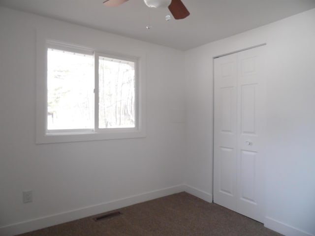 spare room featuring visible vents, ceiling fan, carpet, and baseboards