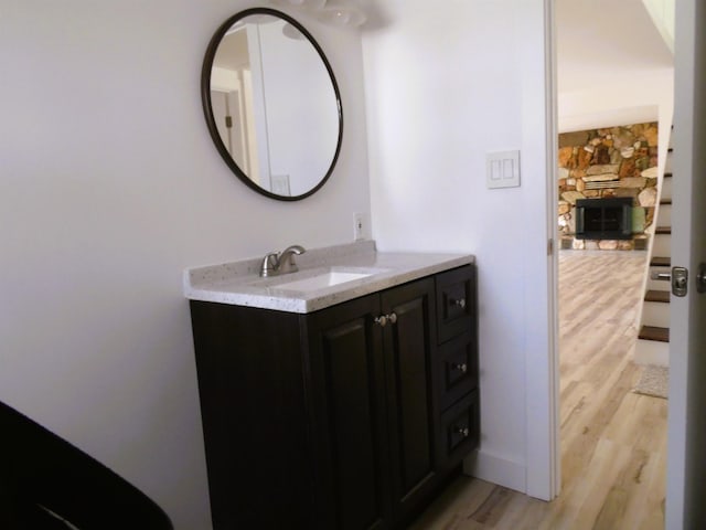 bathroom featuring baseboards, wood finished floors, and vanity