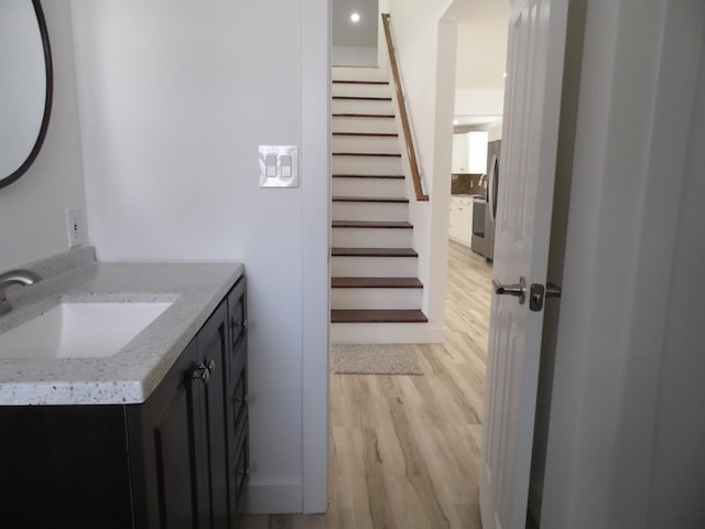 bathroom with vanity, wood finished floors, and tasteful backsplash