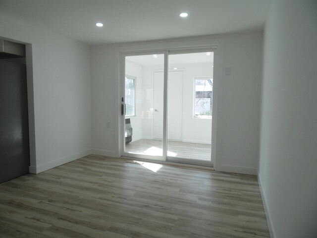 spare room featuring recessed lighting, baseboards, and wood finished floors