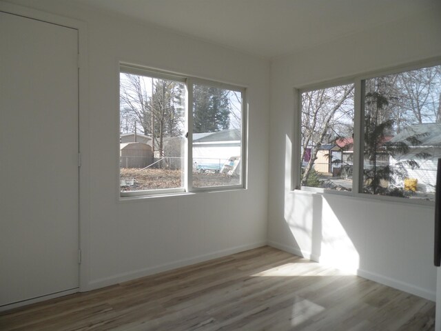 unfurnished room with baseboards and wood finished floors