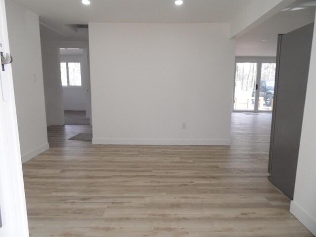 spare room with recessed lighting, light wood-type flooring, and baseboards