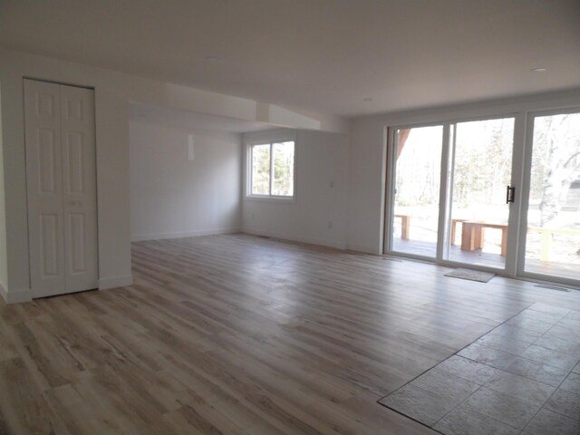 empty room featuring visible vents, wood finished floors, and baseboards