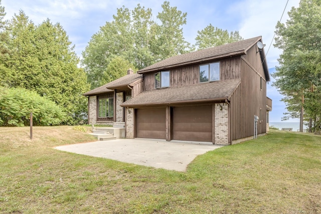 view of front of home featuring brick siding, a shingled roof, a front lawn, a chimney, and driveway