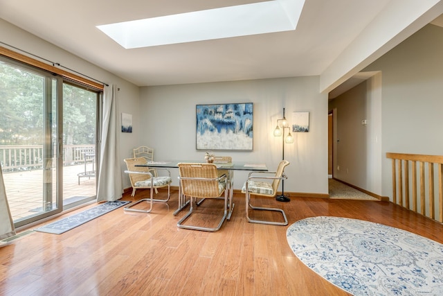 dining area with visible vents, a skylight, baseboards, and wood finished floors