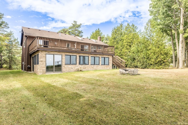 back of house featuring a wooden deck, stone siding, and a yard