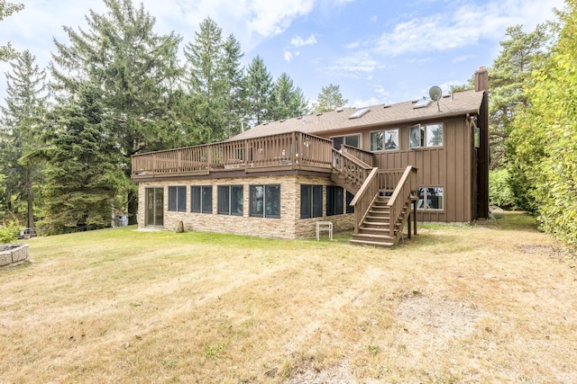 back of house with a wooden deck, a yard, a chimney, stairs, and board and batten siding