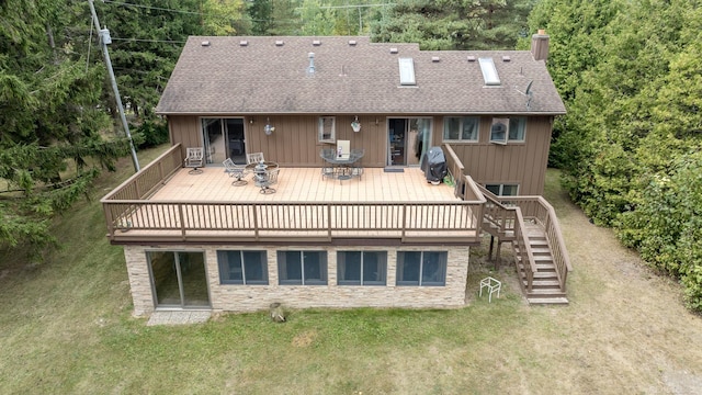 back of house with stairway, a wooden deck, roof with shingles, a chimney, and a yard