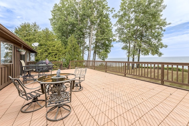 view of patio with outdoor dining area and a deck with water view