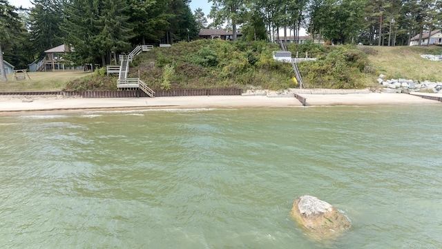 water view with stairway and a beach view