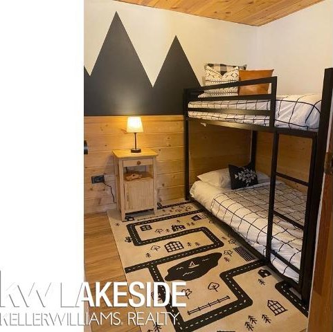 bedroom featuring wood finished floors, wooden walls, and wood ceiling