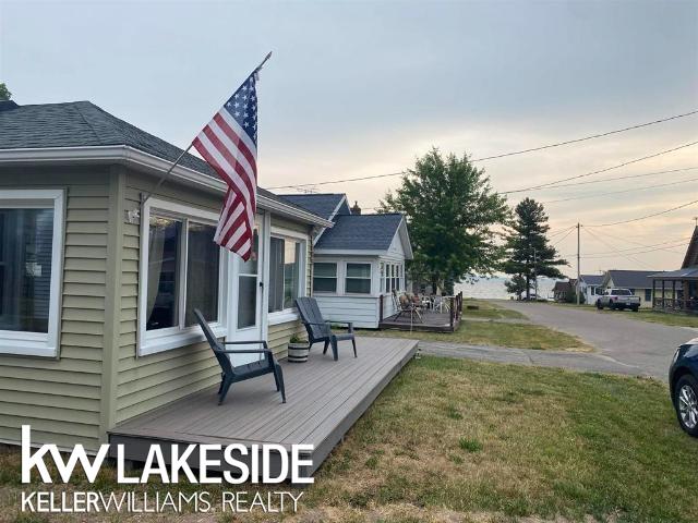 view of side of property with a wooden deck and a lawn