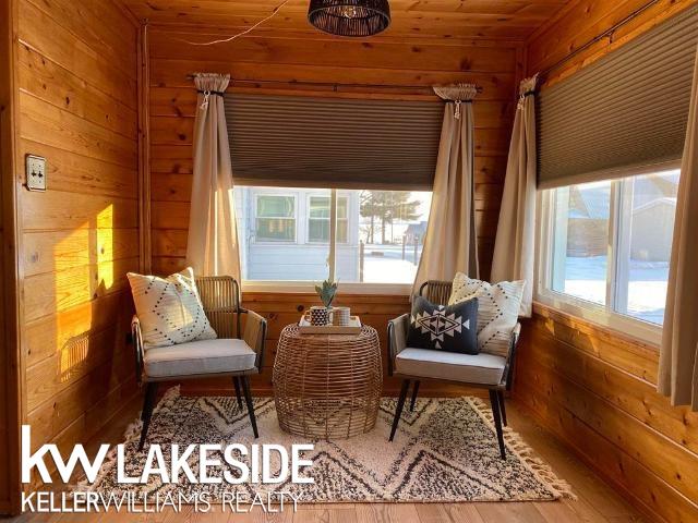 sitting room with wooden walls and wood finished floors