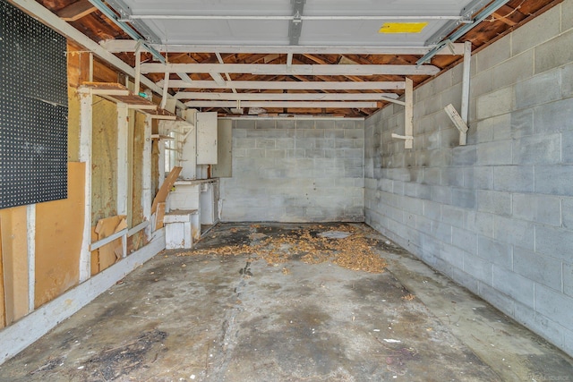 basement featuring a garage and concrete block wall