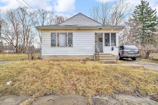 bungalow-style house with a front yard and fence