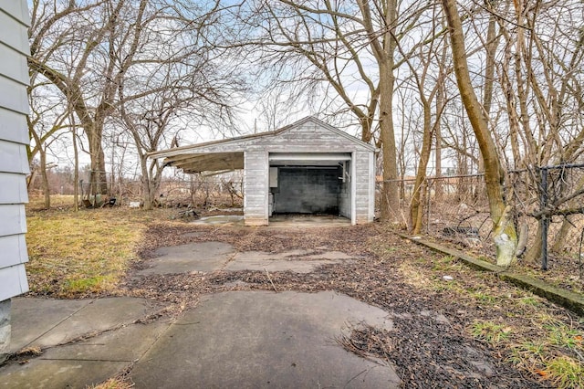 exterior space with an outdoor structure, fence, a garage, and driveway