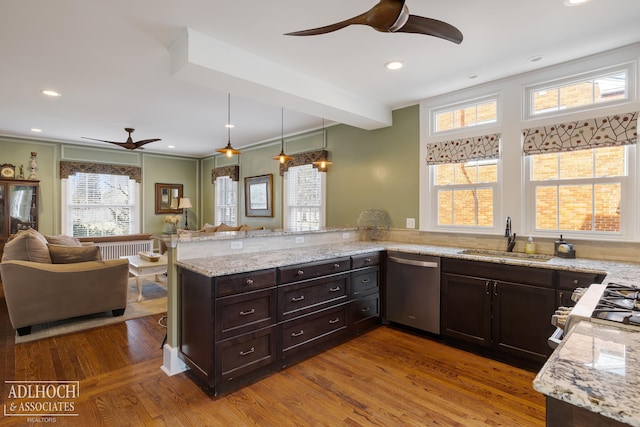 kitchen with a peninsula, a sink, open floor plan, dishwasher, and light wood-type flooring