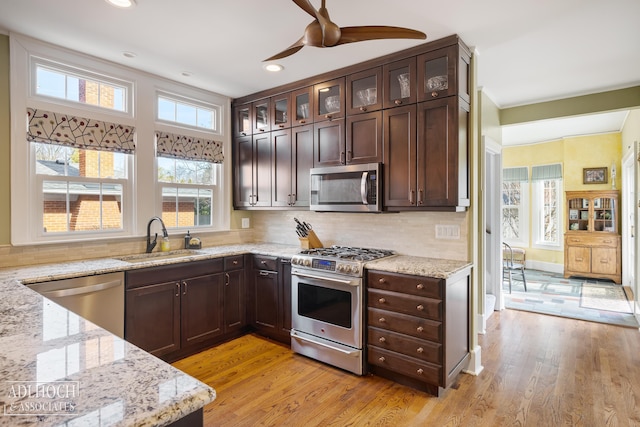 kitchen featuring a sink, dark brown cabinetry, light wood-type flooring, and stainless steel appliances