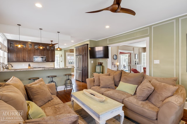 living area featuring dark wood finished floors, crown molding, recessed lighting, and ceiling fan