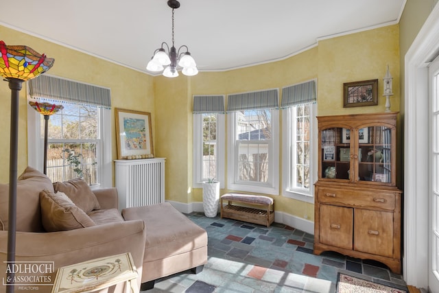 sitting room featuring stone tile floors, an inviting chandelier, baseboards, and ornamental molding