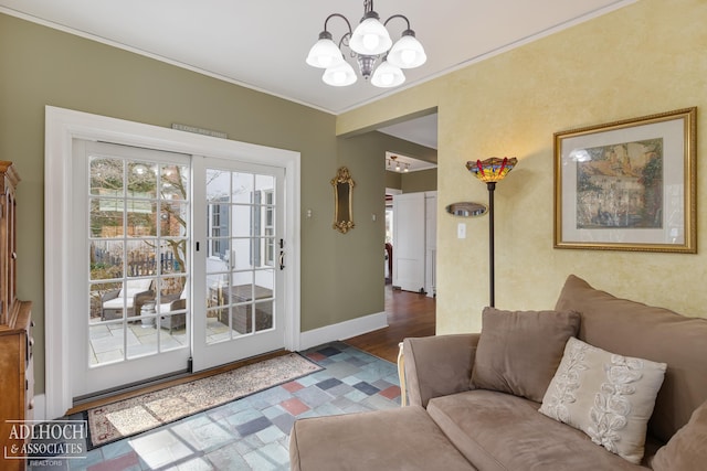 entryway with baseboards, a notable chandelier, and crown molding