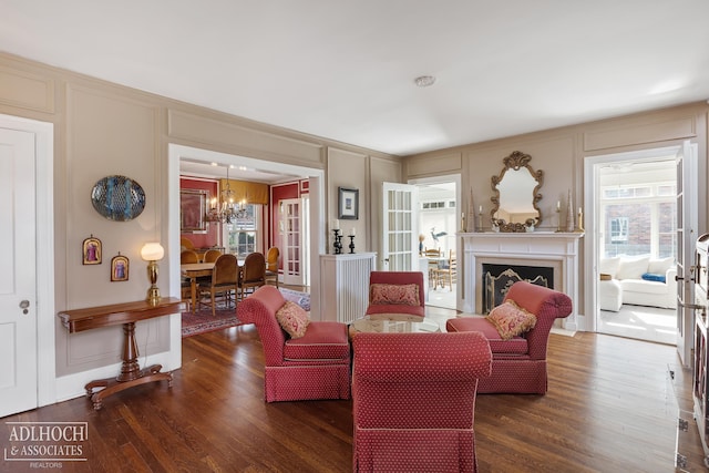 living area featuring a decorative wall, a healthy amount of sunlight, a fireplace, and wood finished floors