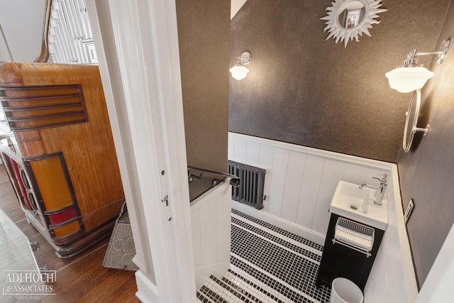 bathroom featuring wood finished floors and a wainscoted wall