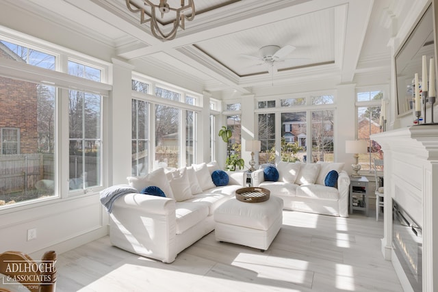 sunroom with a glass covered fireplace, beamed ceiling, coffered ceiling, and ceiling fan