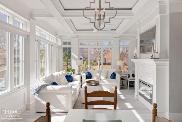 sunroom / solarium featuring a chandelier, a glass covered fireplace, beamed ceiling, and coffered ceiling