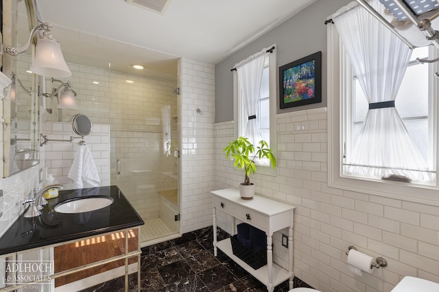 bathroom with vanity, visible vents, a stall shower, tile walls, and toilet