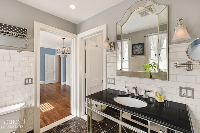 bathroom featuring visible vents, toilet, marble finish floor, tasteful backsplash, and vanity