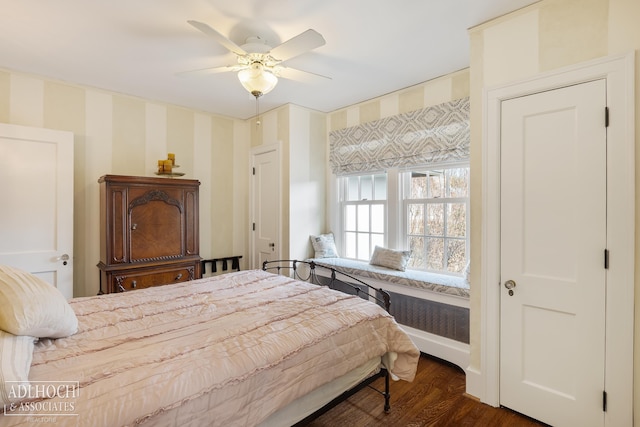 bedroom featuring ceiling fan, baseboards, dark wood-style floors, and wallpapered walls