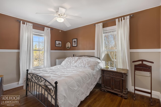 bedroom featuring radiator, baseboards, dark wood finished floors, ceiling fan, and ornamental molding