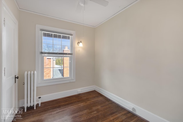 unfurnished room with radiator heating unit, crown molding, baseboards, ceiling fan, and dark wood-style flooring