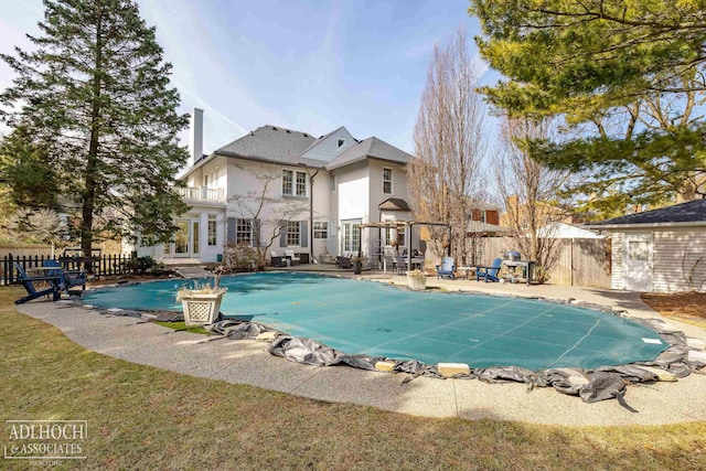 rear view of house featuring a patio, a fenced in pool, a fenced backyard, stucco siding, and french doors