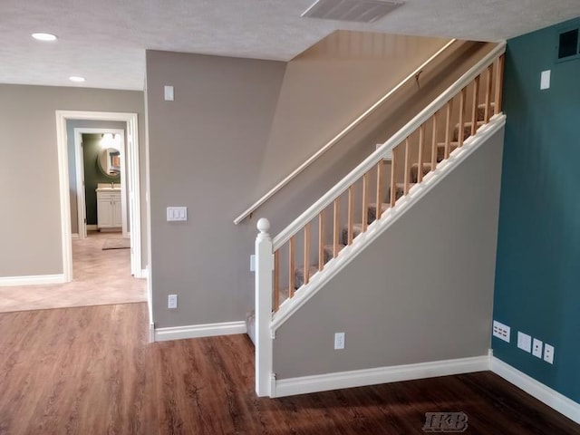 stairs featuring visible vents, recessed lighting, baseboards, and wood finished floors