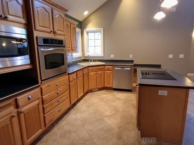 kitchen featuring a sink, stainless steel appliances, lofted ceiling, and dark countertops