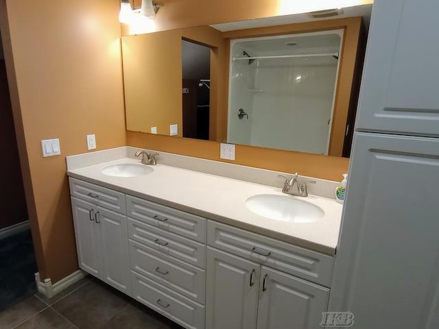 bathroom with tile patterned floors, double vanity, and a sink