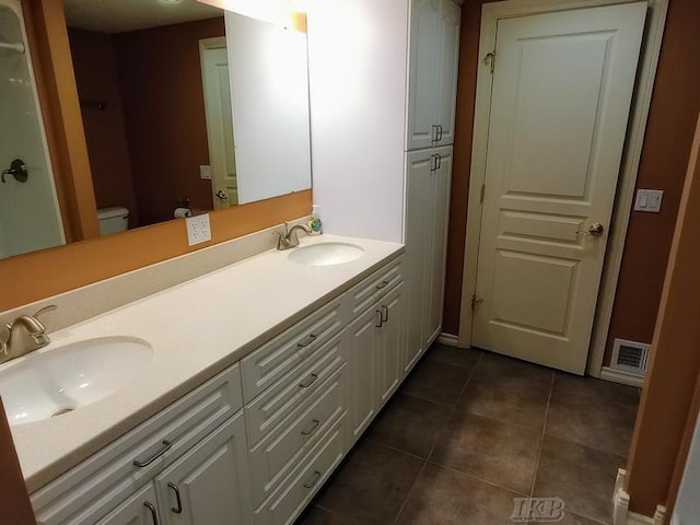 full bath with tile patterned flooring, toilet, visible vents, and a sink