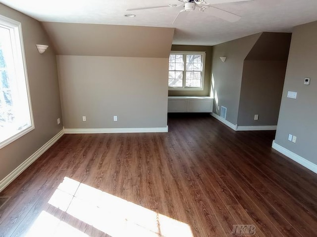 bonus room featuring visible vents, wood finished floors, baseboards, ceiling fan, and vaulted ceiling