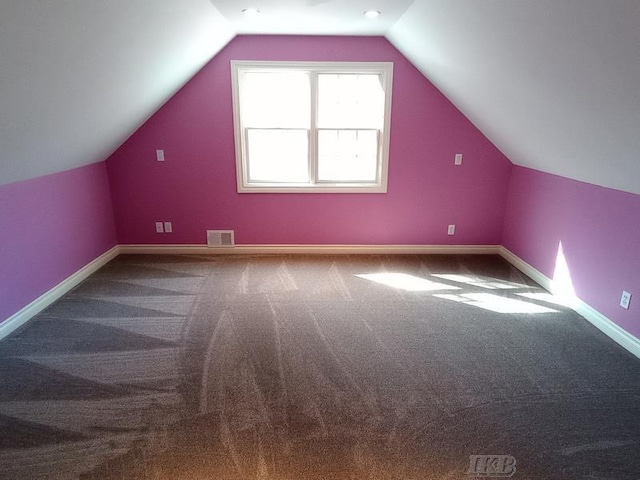 additional living space with visible vents, baseboards, lofted ceiling, and carpet floors