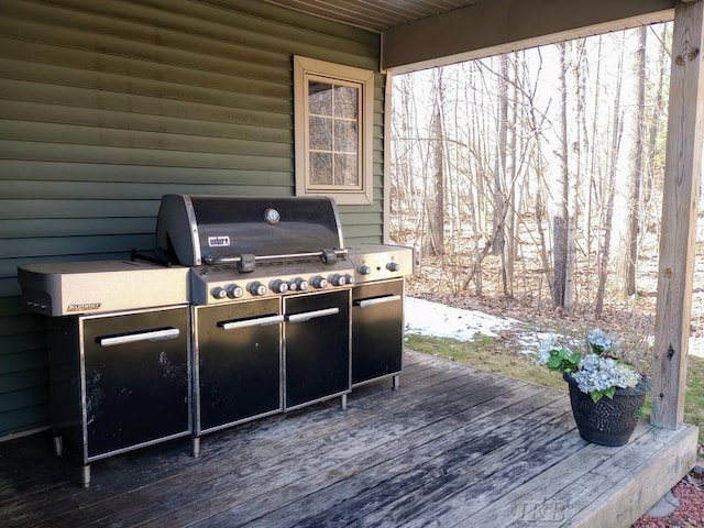 wooden terrace with area for grilling and an outdoor kitchen