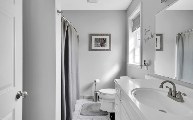 bathroom with vanity, a shower with shower curtain, toilet, and baseboards