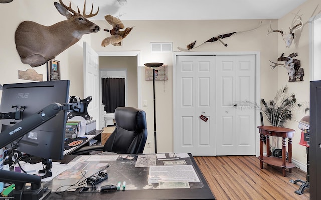 home office featuring visible vents and wood finished floors