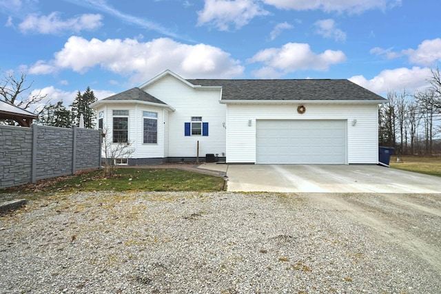 view of front of home with fence, a garage, driveway, and roof with shingles