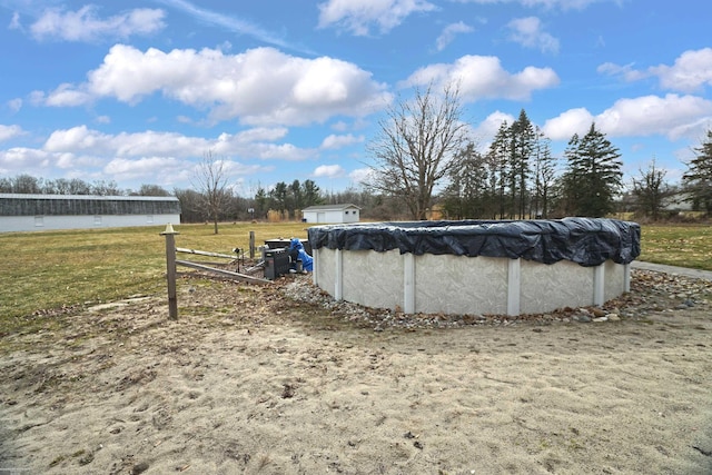 view of pool featuring a covered pool, an outbuilding, and a lawn