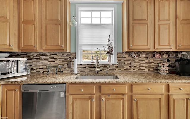 kitchen featuring light stone counters, light brown cabinetry, a sink, stainless steel dishwasher, and tasteful backsplash